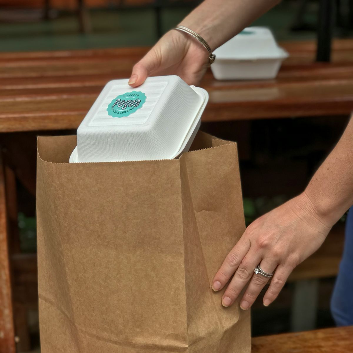 Business owner packing takeaway bag with burger box